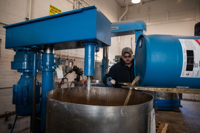 Production adding a drum of ingredients to a batch Production adding a drum of ingredients to a batch